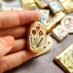 Detailed macro view of an oval tulip ceramic pendant with elegant gold vacuum plating trim