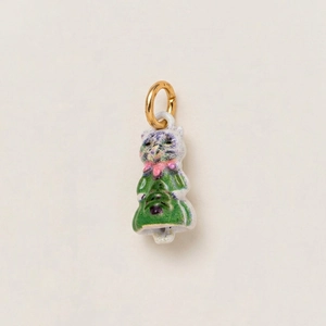 Dettaglio di un ciondolo vintage in ceramica con vestito verde e fiocco rosa