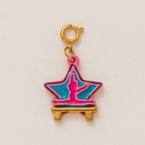Macro detail of star shaped gold pendant with pink and blue enamel and spring clasp