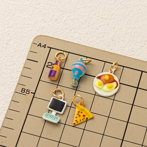 Dettagli di cinque ciondoli creativi in smalto con pizza e mongolfiera decorativi