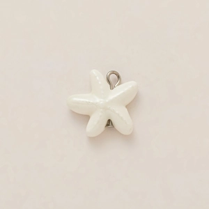 Macro detail of a cream starfish pendant with 18K gold plated loop and grainy texture