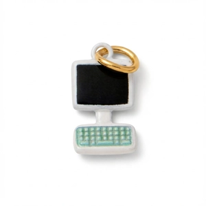 Dettaglio di un portachiavi a forma di computer vintage con smalto bianco e tastiera verde menta
