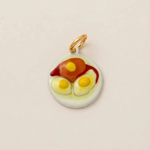 Detail van creatieve ronde hanger met gebakken ei patroon, gouden ring en email