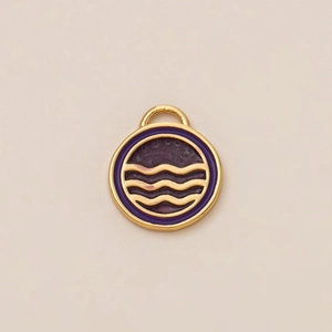 Vista macro de un colgante redondo dorado con esmalte morado y tres ondas