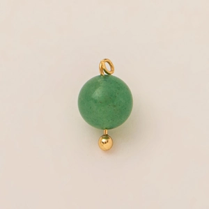 Detalle de colgante de jade verde con aro dorado y pequeño acento de bola metálica