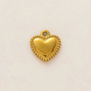 Detail of 18K gold plated heart pendant with beaded edge and polished finish