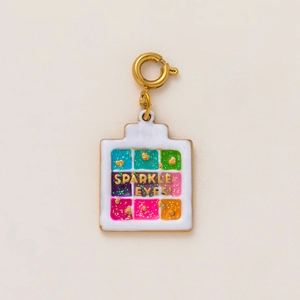 Detailed macro of a 18K gold-plated eyeshadow palette pendant with colorful enamel cubes