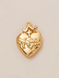 Detail of a 18K gold-plated Sacred Heart pendant with cross and flame relief design