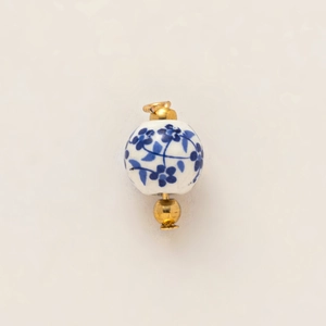 Detail of blue floral porcelain bead pendant with gold plating and 18K finish