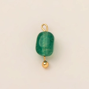 Detalle de un colgante cilíndrico de piedra verde con accesorios chapados en oro de 18 quilates