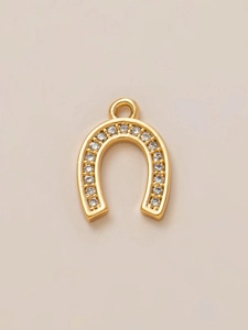 Macro shot of horseshoe charm plated in 18K gold with sparkling cubic zirconia inlay