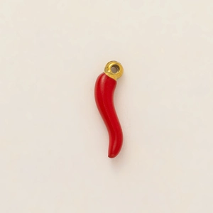 Macro shot of a red Italian horn corno pendant with a golden 18K vacuum plated ring