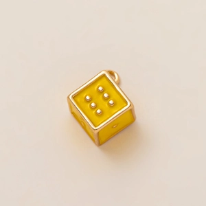 Detailed macro view of yellow enamel dice pendant charm with 18K gold-plated metal finish