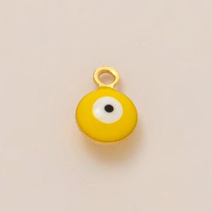 Detail of a yellow evil eye enamel pendant with a gold ring for jewelry making