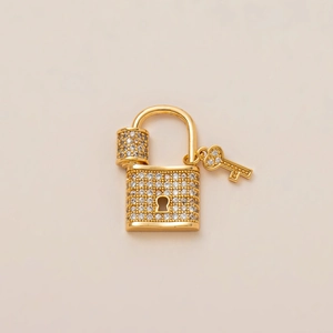 Detail of 18K gold plated padlock and key charm with micro-paved white cubic zirconia stones
