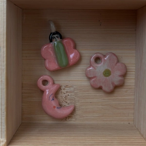 Ensemble de pendentifs en céramique rose avec papillon, fleur et lune sur bois