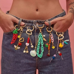 Vibrant DIY 18K gold plated keychain charms and pendants on blue denim jeans