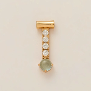 Detalle del colgante bañado en oro con circonitas blancas y piedra ovalada verde