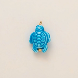 Close-up of blue sea turtle pendant with 18k gold plating and smooth ceramic texture