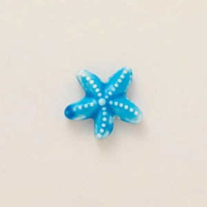 Detail of blue starfish pendant accessory with 18k gold plating and embossed dots
