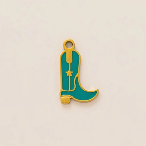Detail of a cowboy boot pendant with gold-plated edges and turquoise enamel inlay