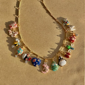 Gold-plated chain necklace with colorful enamel animal charms like pigs and bees