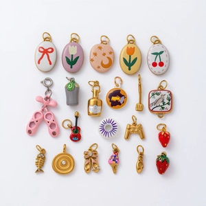 Vue macro des breloques chaussons de danse dorées 18K et pendentifs émail pour bijoux DIY