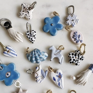 Artistic ceramic heart and flower charms with evil eye patterns on marble background