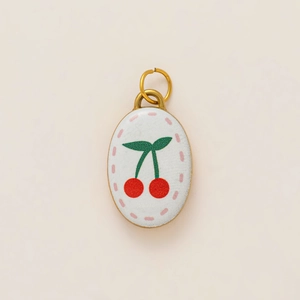 Détail du pendentif ovale plaqué or 18 carats avec émail blanc et motif cerise