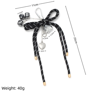 Detail of DIY bow keychain with black dice and silver heart charms in 25cm length