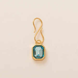 Détail d'un pendentif en pierre bleu clair taille émeraude avec crochet en S doré
