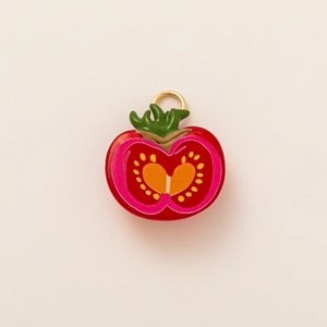 Détail d'un pendentif tranche de tomate éclatante avec anneau doré et émail poli