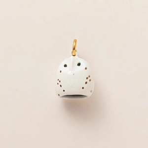 Détail d'une breloque chouette en céramique blanche avec anneau doré pour bijoux