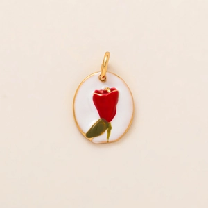 Détail d'un pendentif ovale plaqué or avec émail blanc et un motif floral rouge