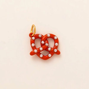 Vue détaillée d'un pendentif bretzel orange avec perles et anneau doré brillant