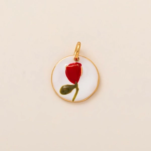 Détail d'un pendentif rond doré en émail blanc avec une rose rouge peinte à la main