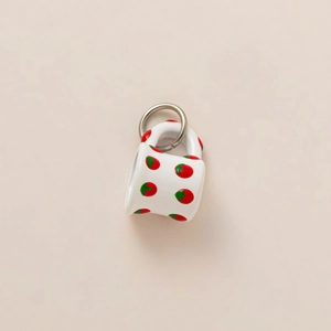 Detail of mini 18K gold strawberry pendant with red and green painted ceramic patterns