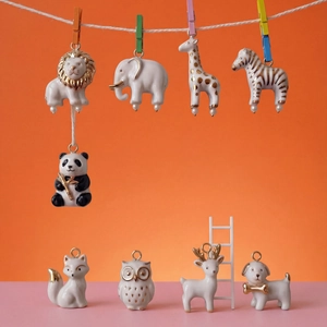 Detailed view of colorful 14K gold-plated ceramic animal charms hanging on a creative rope