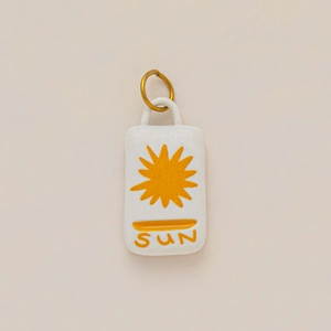 Detalle de colgante rectangular bañado en oro 18K con gráfico de sol y letras SUN