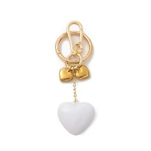 Vue détaillée du charme en forme de cœur avec ferrures dorées et pendentif blanc