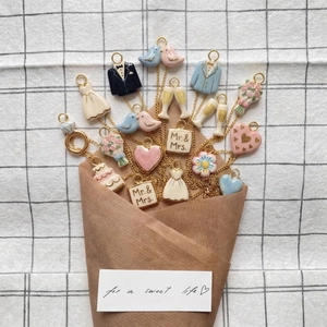 Wedding themed ceramic pendants set with 18K gold plated charms on grid background