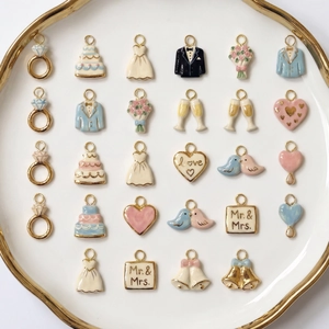 Detailed close-up of mixed wedding charms in a gold-rimmed tray for DIY jewelry