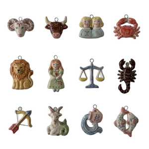 Set of twelve colorful zodiac 18K stainless steel pendants with zircon stones on white backdrop