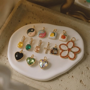 Mix of colorful vintage charms with flowers and hearts in a white ceramic dish