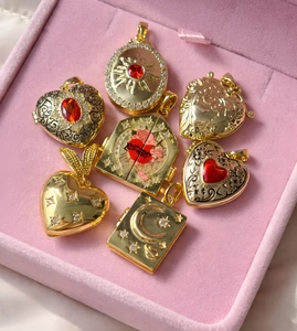 Gedetailleerde opname van diverse 18K vergulde medaillon hangers met vintage bloemengravures