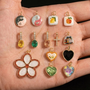 Variety of gold-plated enamel pendants featuring flowers and hearts for DIY jewelry making