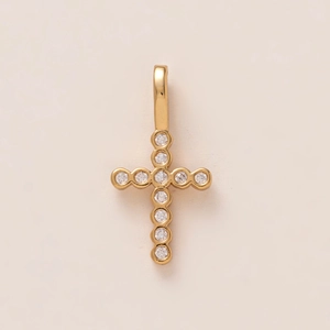 Detailed macro view of an 18K gold plated cross pendant featuring 11 sparkling clear gems