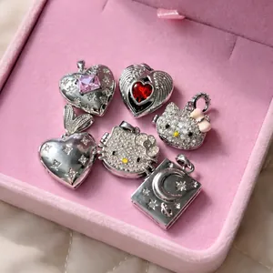 Silver vintage heart and kitten charms with pink stones in a velvet jewelry box