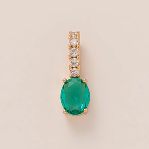 Macro shot of gold-plated emerald pendant with five vertically aligned accent stones