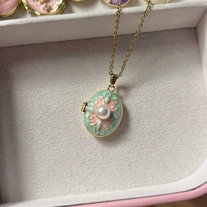 Collar de relicario vintage con esmalte verde pálido, flores rosas y perla central